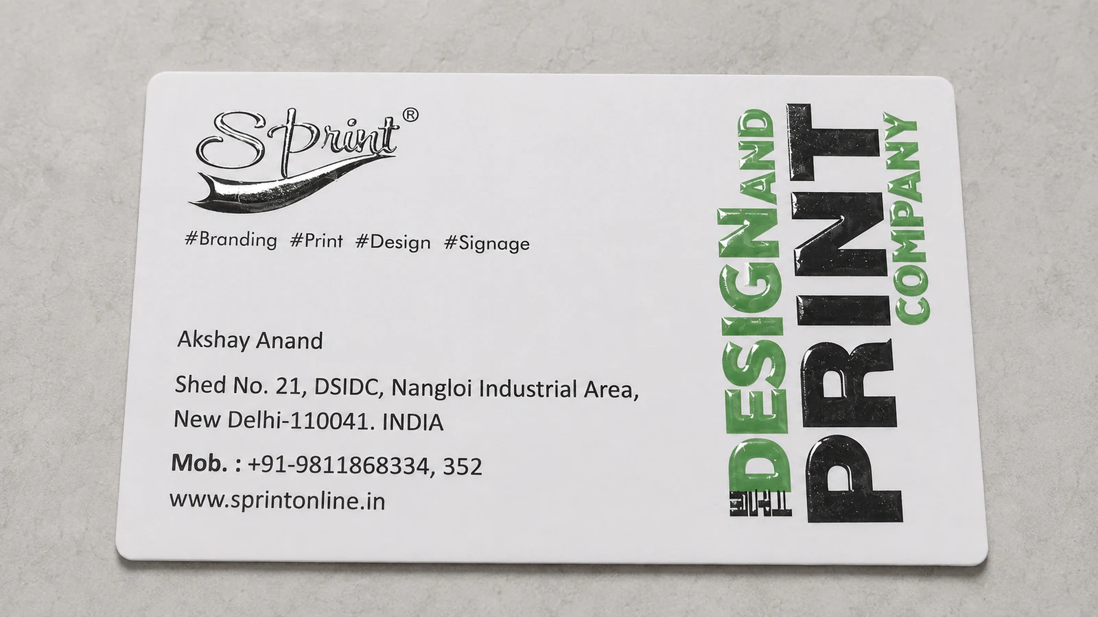 Full view of a white Sprint visiting card with black and green raised spot UV printing.