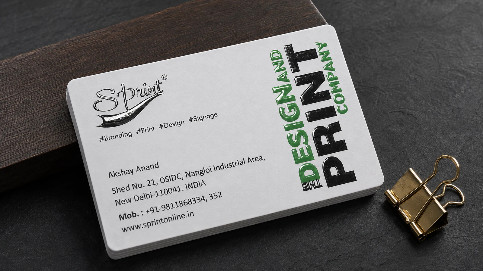 Luxury white visiting card printed in Delhi with black and green raised spot UV details.